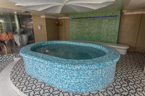 a large blue tub in a bathroom with a shower at Sunny Hill Apartments & Aqua Park in Vrnjačka Banja
