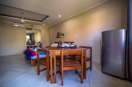 a dining room with a table and a refrigerator at Ossanzaia Bilene Lodge in Vila Praia Do Bilene