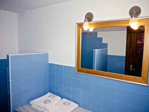 a blue tiled bathroom with a mirror and towels at Olmitos 3, Casa-Palacio Real Piedad in Cehegín