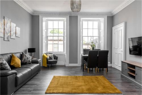 a living room with a couch and a table at Spacious newly refurbished central apt in Edinburgh