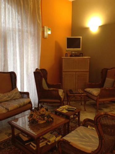 a living room with a couch and chairs and a tv at Aer Hotel Malpensa in Oleggio