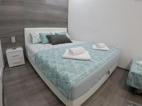a bedroom with a bed with two towels on it at Apartman DMD in Trebinje