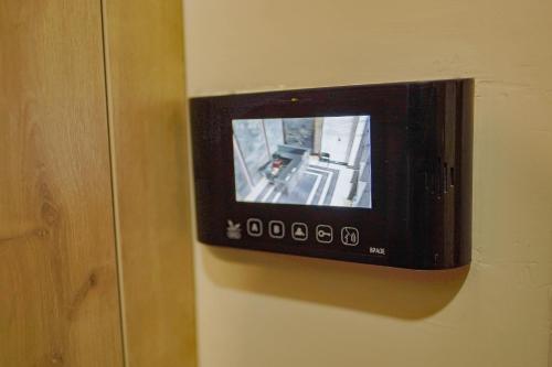 een televisie bevestigd aan een muur met een muur bij Balmaral Apart Hotel in Batoemi