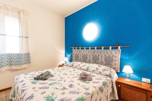 una camera con un letto con una parete blu di Casa vacanze Lungomare a Santa Maria Navarrese