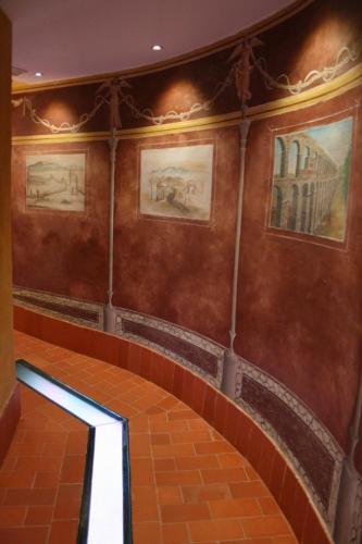 an empty hallway in a building with paintings on the walls at Hotel Spa La Casa Mudéjar in Segovia