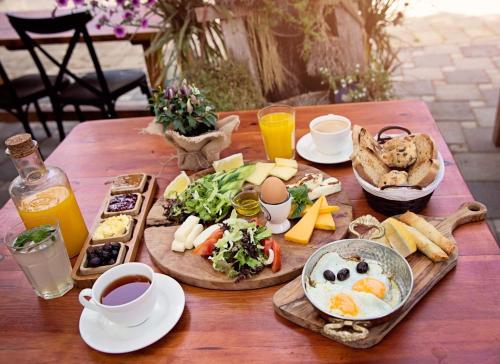 a wooden table with breakfast foods and drinks on it at The Iskemleci Guest House in North Nicosia