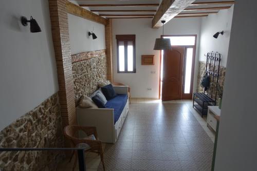 a living room with a couch and a brick wall at Casa La Abuela in Chulilla