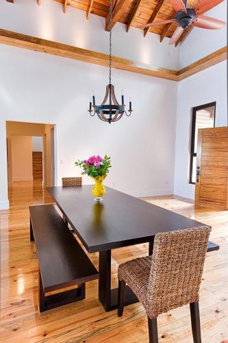 a dining room table with a vase of flowers on it at Vivaro Roatan South House in West End