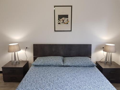a bedroom with a blue bed with two lamps at Quiete ad un passo dal mare in Albisola Superiore