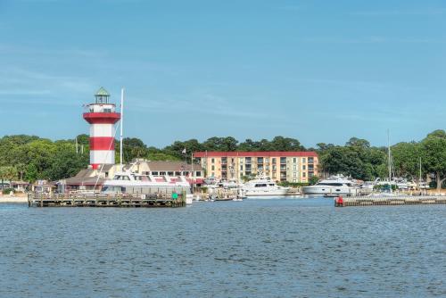 a red and white lighthouse on the water with boats at Saint Andrews Common 1774 in Hilton Head Island