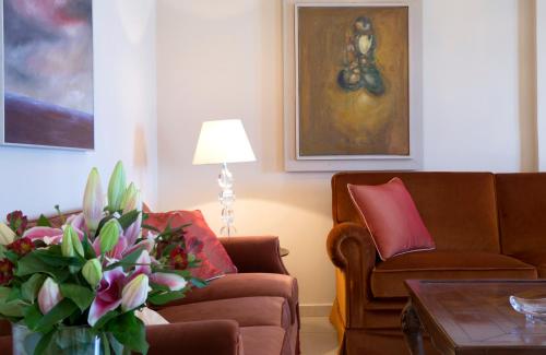a living room with two couches and a vase of flowers at Avra Private Suites in Lassi