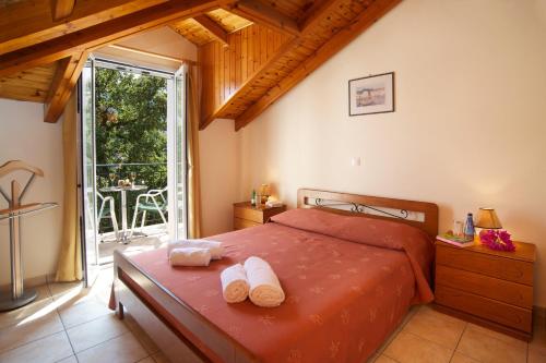 a bedroom with a bed with two towels on it at Faos Luxury Apartments in Ayia Evfimia