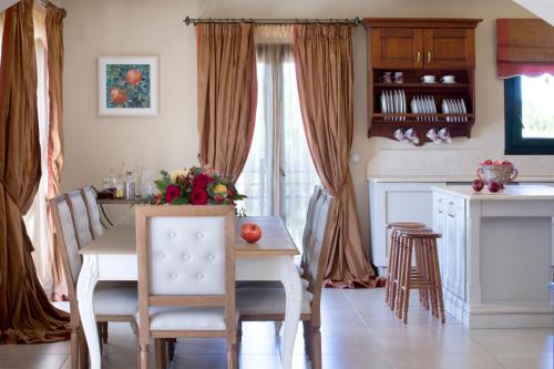a kitchen and dining room with a table and chairs at Avra Private Suites in Lassi