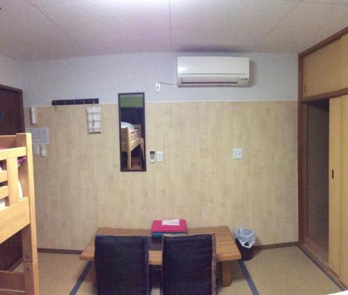 Cette chambre dispose d'une table avec des chaises et de la climatisation. dans l'établissement Gaisei Building 3F / Vacation STAY 4092, à Kyoto
