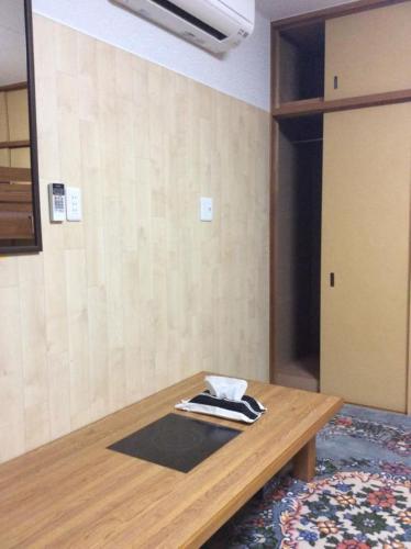 Cette chambre dispose d'une table en bois et d'une porte. dans l'établissement Gaisei Building 3F / Vacation STAY 4092, à Kyoto