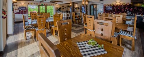 a restaurant with wooden benches and tables in a room at La Conacul Vesel Săpânța in Săpînţa