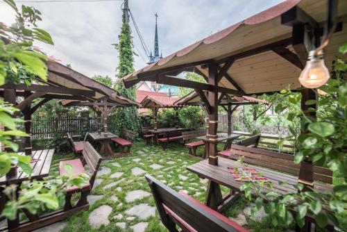 a patio with benches and tables in a garden at La Conacul Vesel Săpânța in Săpînţa