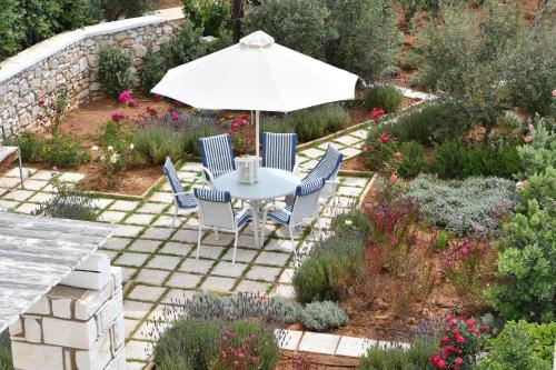 a patio with a table and chairs and an umbrella at Villa Dinos in Aliki
