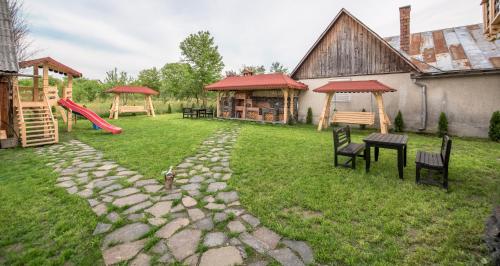 a backyard with a playground with a slide and benches at La Conacul Vesel Săpânța in Săpînţa