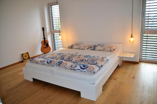 Un dormitorio con una cama y una guitarra. en Passivhaus Hannover Messe en Hannover