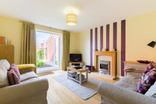 a living room with two couches and a fireplace at Riverside cottage in Evesham