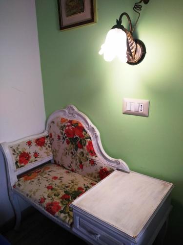 a chair in a room with a light on a wall at For Ever Apartments in Fiumicino
