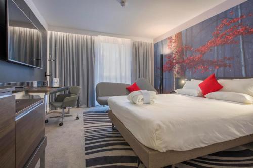 a hotel room with a bed and a desk and a room at Novotel York Centre in York