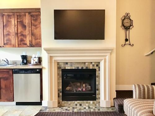a living room with a fireplace and a television at Oceano Hotel and Spa Half Moon Bay Harbor in Half Moon Bay