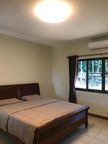 a bedroom with a bed and a large window at House of Garden in Chiang Rai