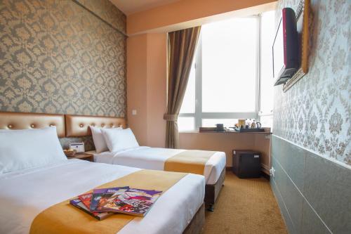 a hotel room with two beds and a window at Best Western Hotel Causeway Bay in Hong Kong