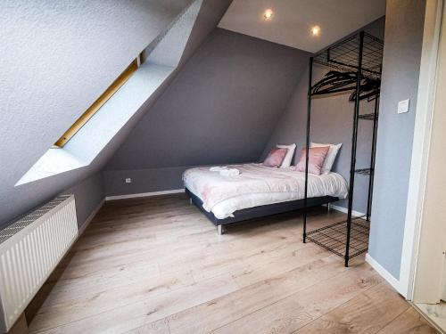 a bedroom with a bed in a attic at Gites Spa Strasbourg - La Villa 11 in Ittenheim