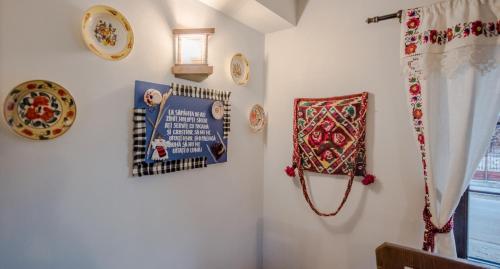 a room with a wall with decorations on it at La Conacul Vesel Săpânța in Săpînţa