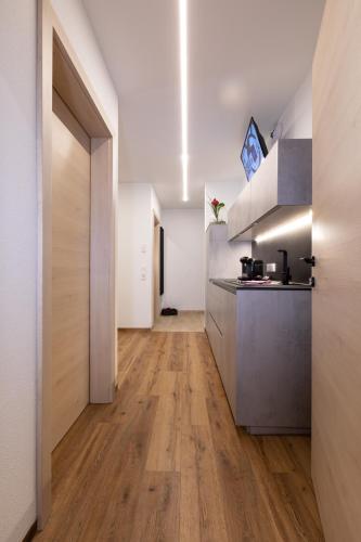 a kitchen with wooden floors and a hallway at ImPuls | aparts in Schladming