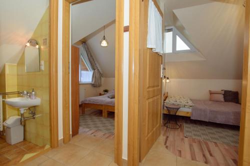 une salle de bains avec lavabo et une chambre avec 2 lits dans l'établissement Pokoje u Ewy, à Kościelisko