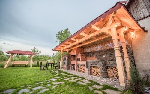 a pavilion with a fireplace in a yard at La Conacul Vesel Săpânța in Săpînţa