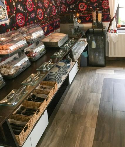 a kitchen with a counter with plates and dishes at La Conacul Vesel Săpânța in Săpînţa
