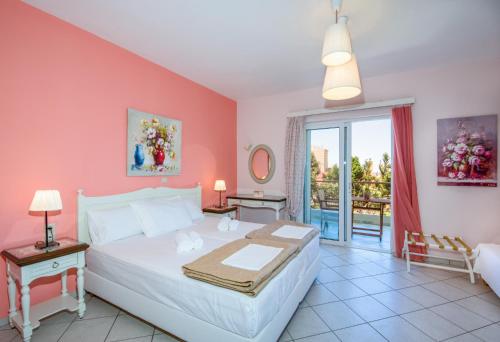 - une chambre avec un grand lit aux murs roses dans l'établissement Stamatakis Boutique Studios, à Platanias