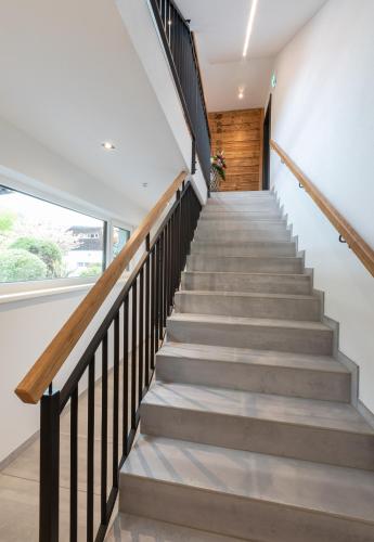 a staircase in a house with white walls and wood at ImPuls | aparts in Schladming