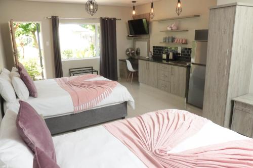 a bedroom with two beds and a kitchen at Patterson B&B in Newcastle