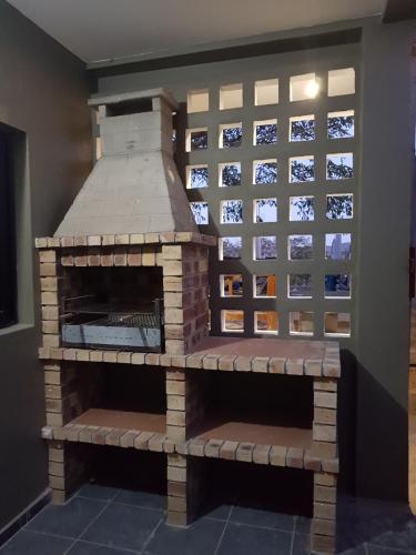a brick pizza oven with a wall of windows at Ossanzaia Bilene Lodge in Vila Praia Do Bilene