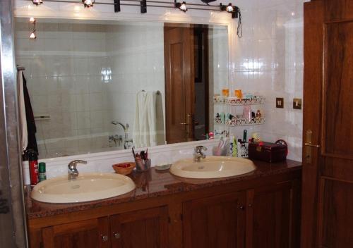 a bathroom with two sinks and a large mirror at B&B La Pilastrina in Maranello