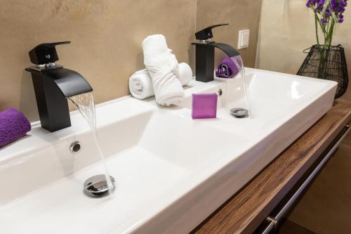 a bathroom sink with towels and a faucet at ImPuls | aparts in Schladming