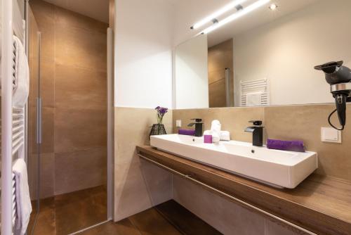 a bathroom with a white sink and a mirror at ImPuls | aparts in Schladming