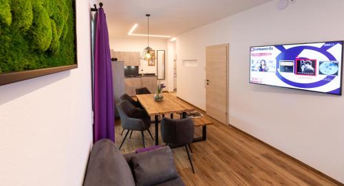 a living room with a dining room table and a tv at ImPuls | aparts in Schladming