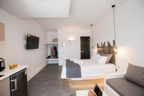 a white bedroom with a bed and a couch at Merchia Bay Villas Mykonos in Merchia Beach