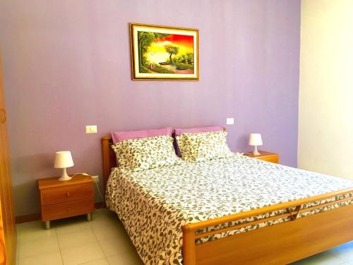 una camera da letto con un letto e un dipinto sul muro di Apartment Arianna 150mt from beach a Castelsardo