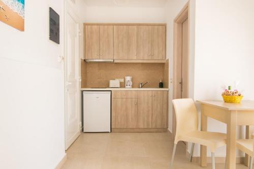 a kitchen with a white refrigerator and a table at Porfyris Studios and Apartments in Karpathos Town