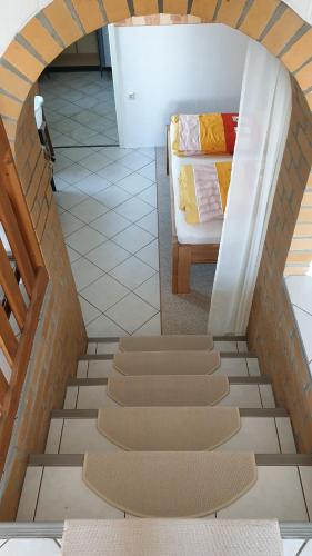 a room with a bed and a staircase with carpet at Pension Münch "Am Anger" in Neuseußlitz