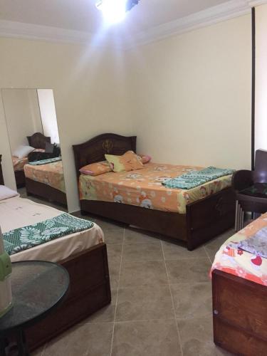 um quarto com duas camas e uma mesa em Agami Apartment em Alexandria