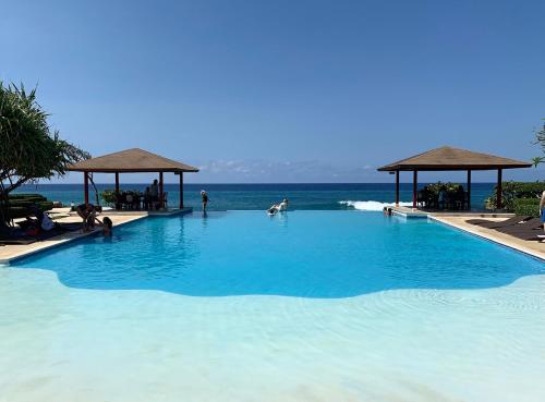 a large swimming pool with the ocean in the background at Casa Coral Sosua in Sosúa